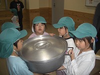 大きな鍋を持っている