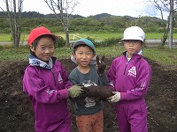 さつまいもを持っている子供たち