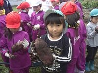 さつまいもを持っている子どもたち