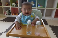 ボトルを前に微笑む赤ちゃん