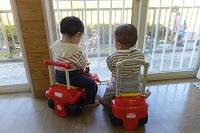 窓辺で車に乗り外を眺めている男の子と女の子