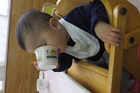 カップをもって飲んでいる男の子の横顔