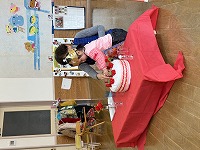 クッションケーキにいちごを飾っているお誕生児