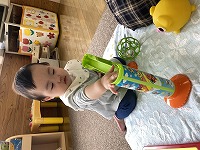 穴におもちゃを入れて遊ぶ１０カ月の女の子