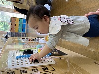 ビジーボードで遊ぶ１０ヶ月の女の子