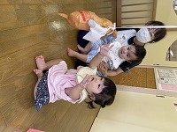 ぶら下がっているおもちゃをつかまえようとする女の子