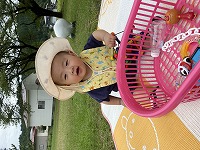 公園で帽子をかぶって座っている男の子