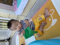 水遊びで漏斗を持つ男の赤ちゃん