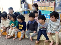 絵本の読み聞かせを見ている子ども達