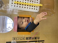 小窓から顔と手を出している男の子