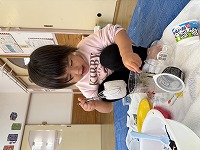 雪をカップに入れて楽しんでいる子ども