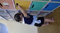 引き出しにつかまり立する女の子の赤ちゃんの後ろ姿