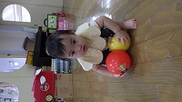 ボールを2つ抱えようとする女の赤ちゃん