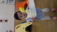 カゴを運ぶ女の赤ちゃん
