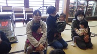 座っている先生と子ども達