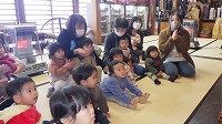 座っている先生と子ども達
