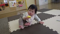 手の中の玩具を見ている赤ちゃん