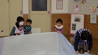 大きな布に触れて喜ぶ子ども達